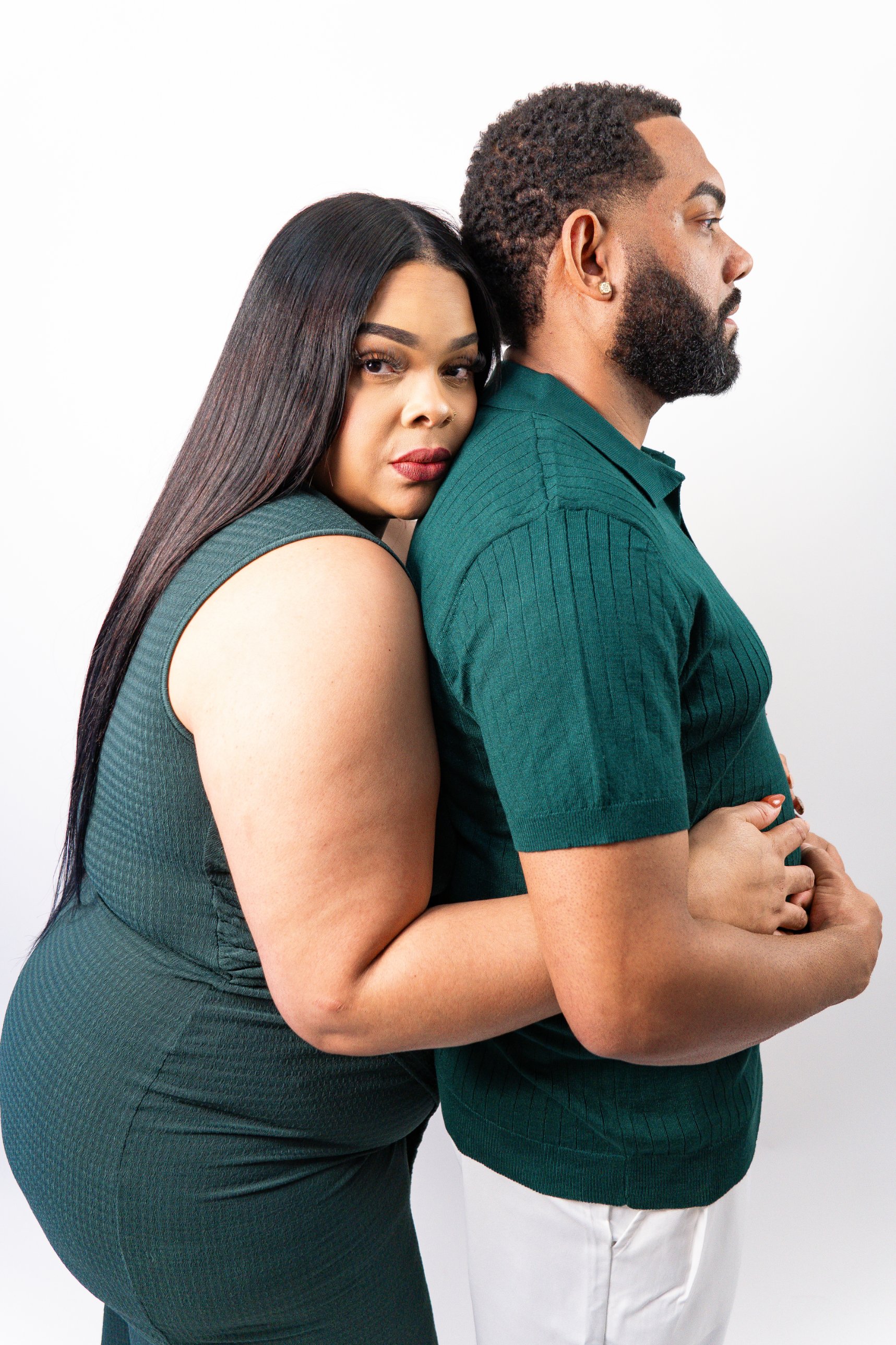 Couple in matching green, embracing in profile