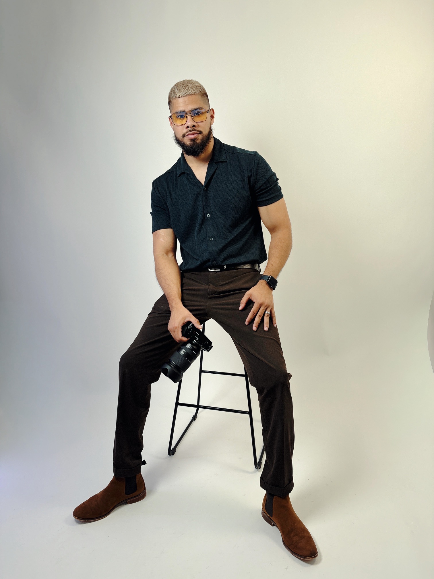 Full-length portrait seated on a stool in the studio